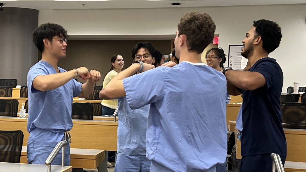 students in scrubs stand in dance circle