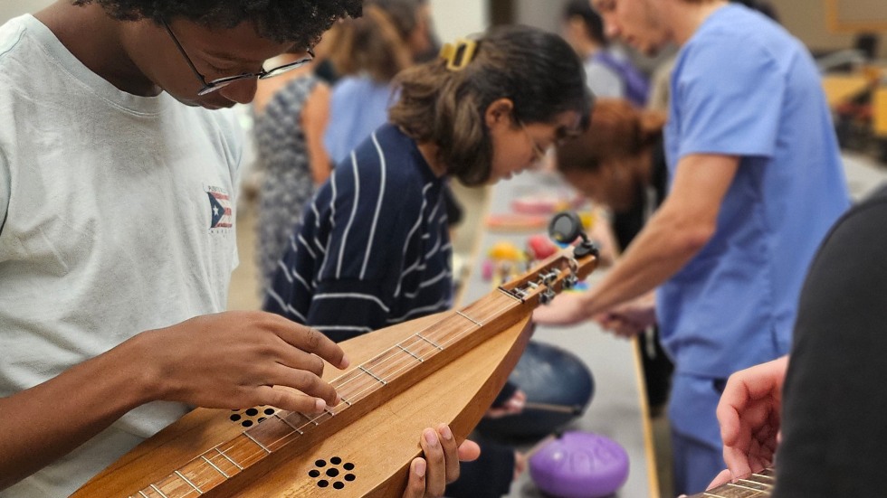 student plucking on an instrument