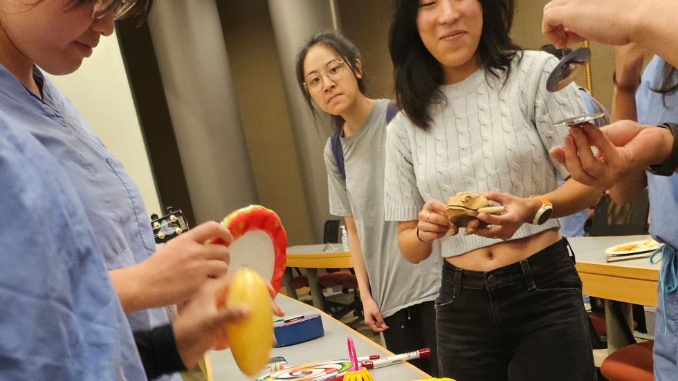 students in scrubs gathering around exotic instruments