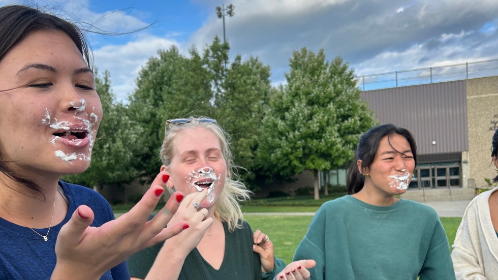 students laughing with whipped cream on their faces